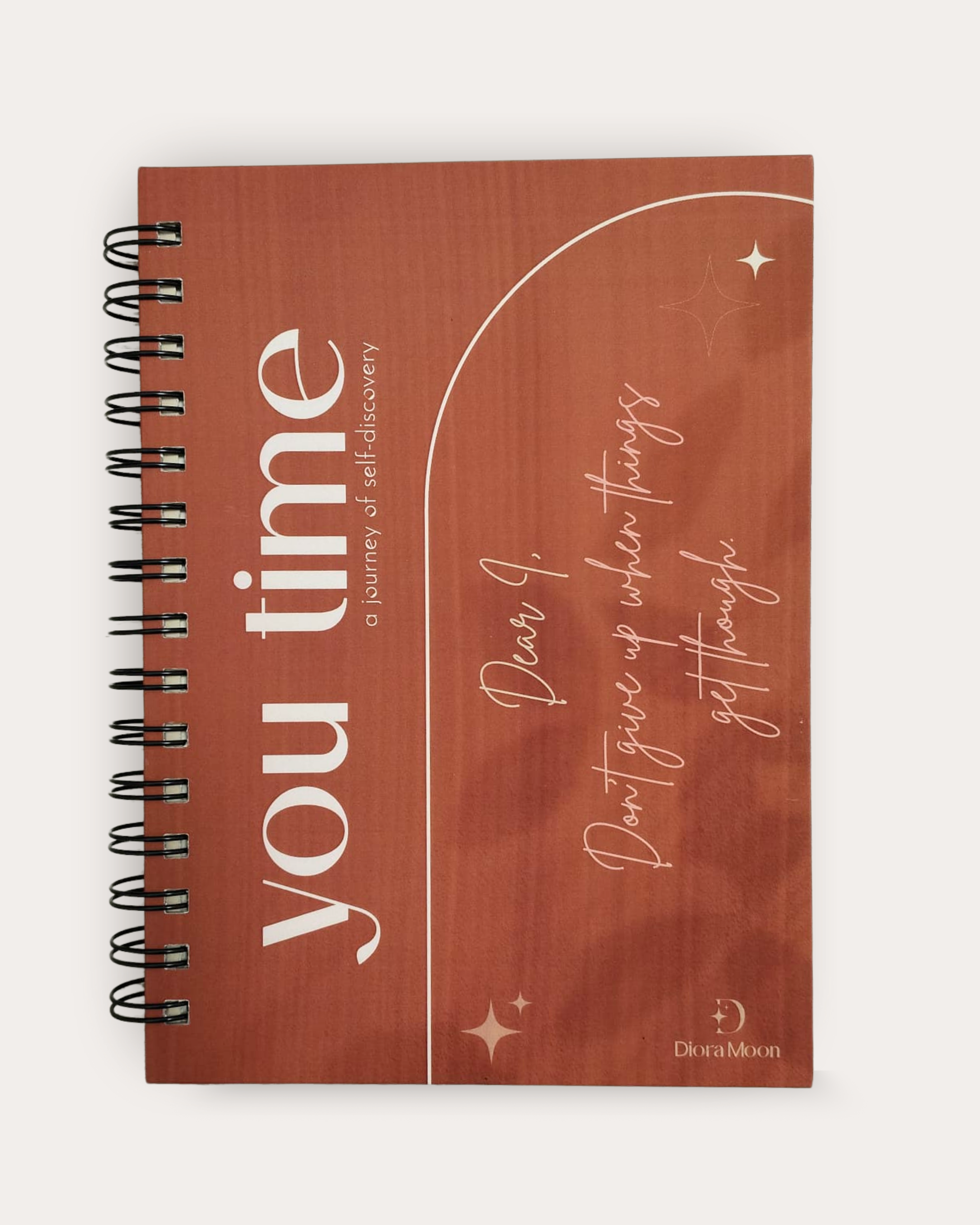 Brown notebook with motivational text on a white background