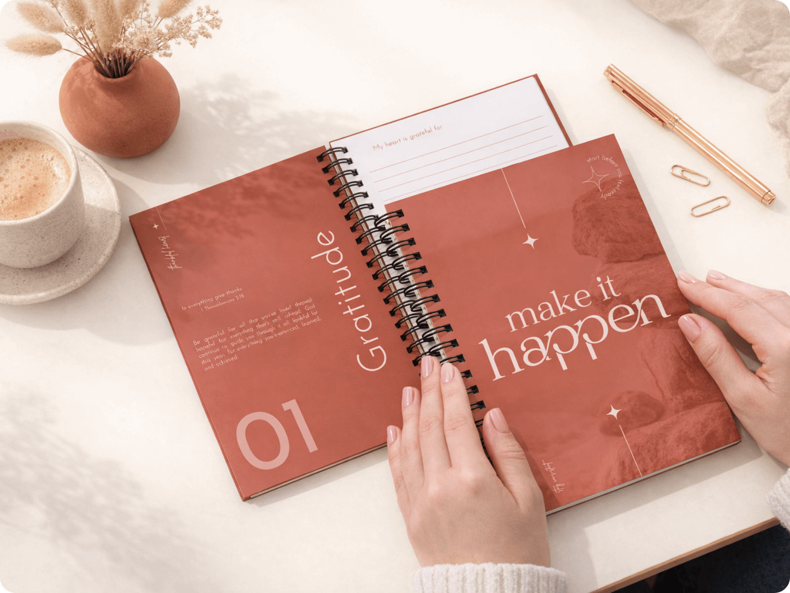 Open spiral-bound notebook with motivational text on a desk with a cup of coffee and decorative items.