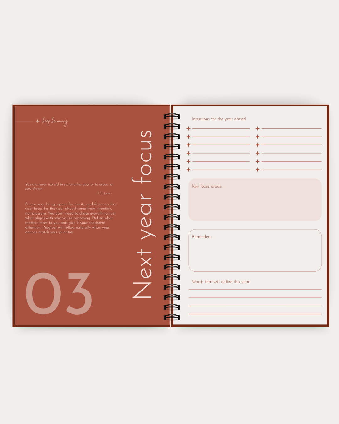 An open spiral-bound journal or planner spread showing a 'Next year focus' page with a terracotta left panel, cream right panel, and lined writing sections.